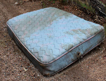 An old mattress ready to be removed from a property.