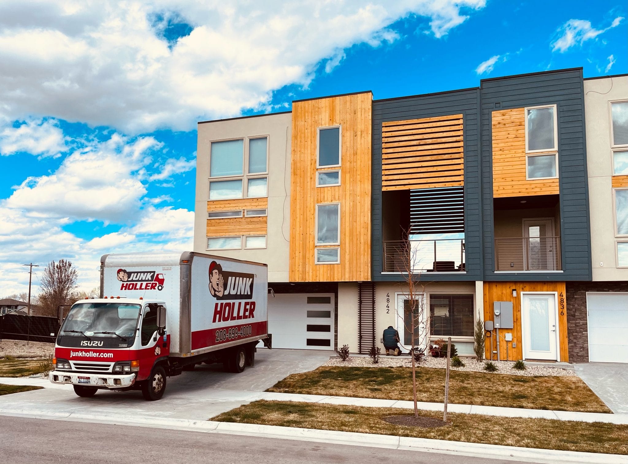Junk Holler truck outside a local residential home providing garage cleanout services. - Junk Holler | Boise, ID